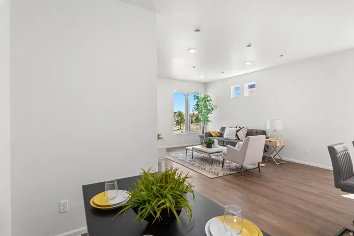 Open-concept living space with wood-finish flooring, recessed lighting, and multiple windows