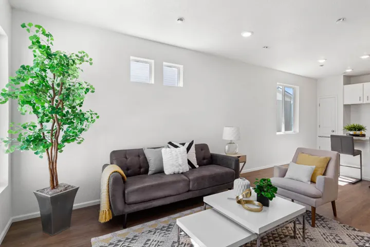 Recessed lighting, wood-finish flooring, white walls, multiple windows, and white cabinetry