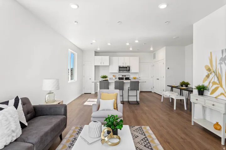 Open-concept living space featuring wood-finish flooring, recessed lighting, and white walls
