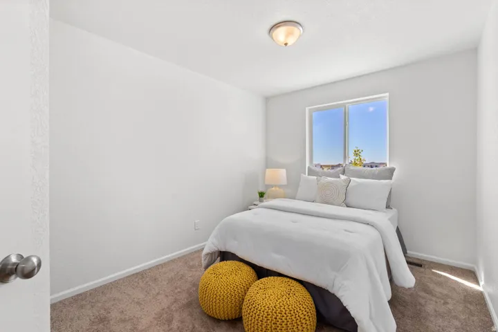 Recessed window with clear glass, overhead flush mount light fixture, neutral tone carpeting, white painted walls, and a white door with brushed nickel hardware