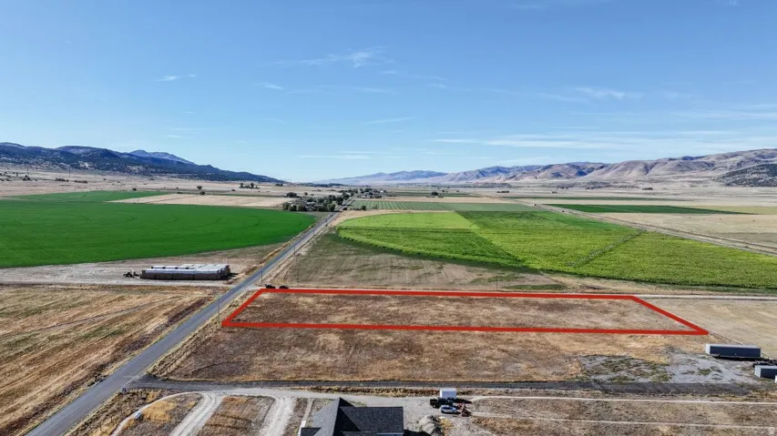 Expansive land parcel with surrounding agricultural fields and distant mountains