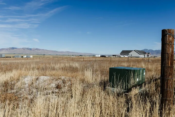 Expansive undeveloped land featuring natural grasses and distant mountain ranges