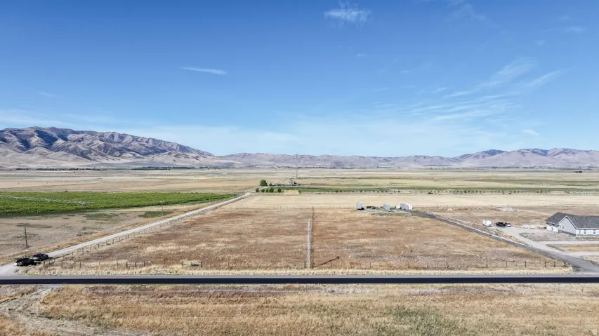 Expansive land parcel featuring clear skies, distant mountain ranges, and open fields