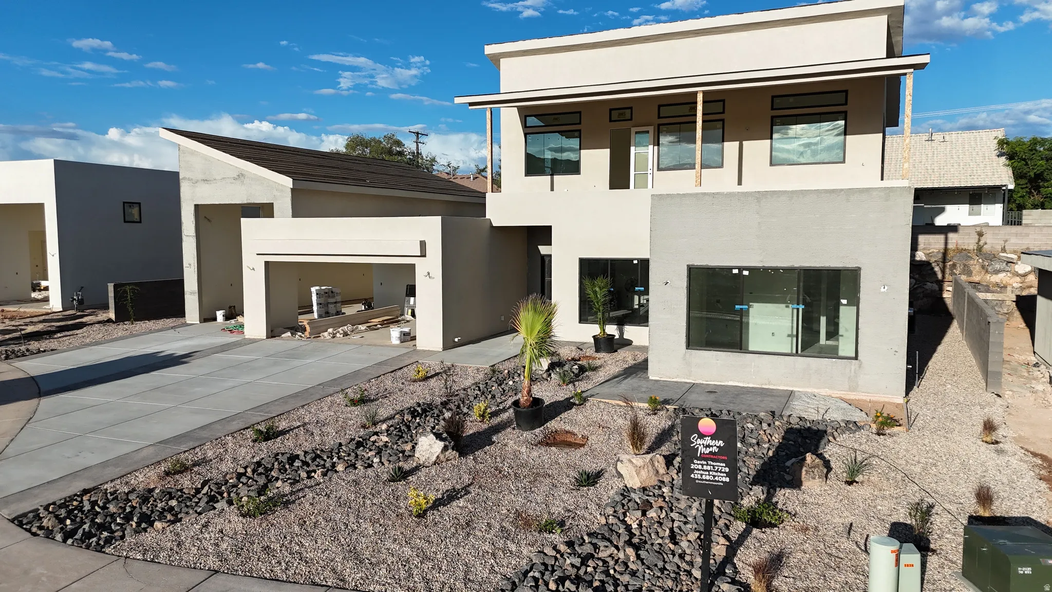 Modern architectural design featuring a two-story elevation, flat roofline, and attached garage