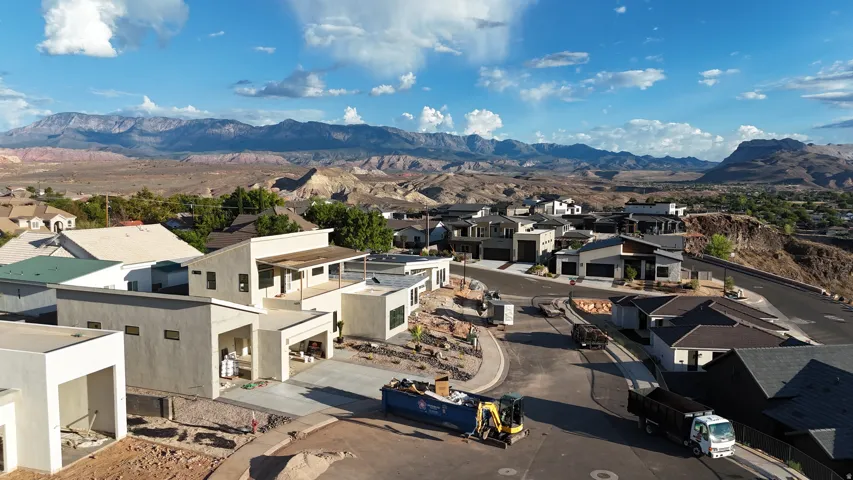 New construction homes featuring contemporary architectural designs, multi-level layouts, attached garages, and a mountain backdrop