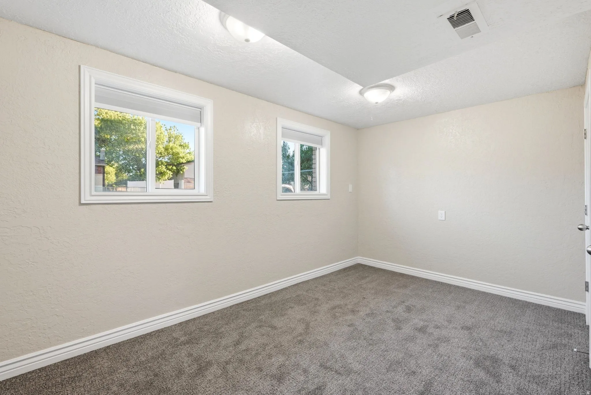 Neutral-toned walls complement the gray carpeting