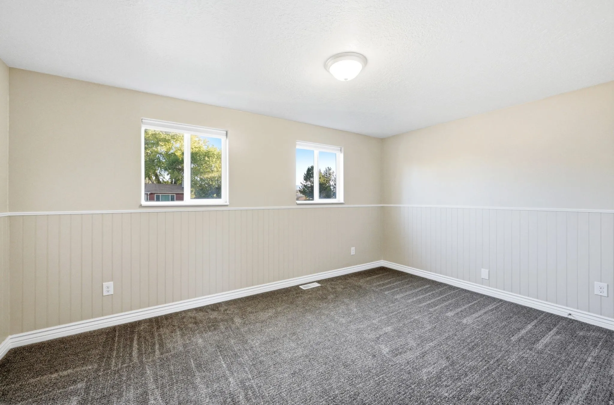 Neutral wall paint with wainscoting detail and two windows