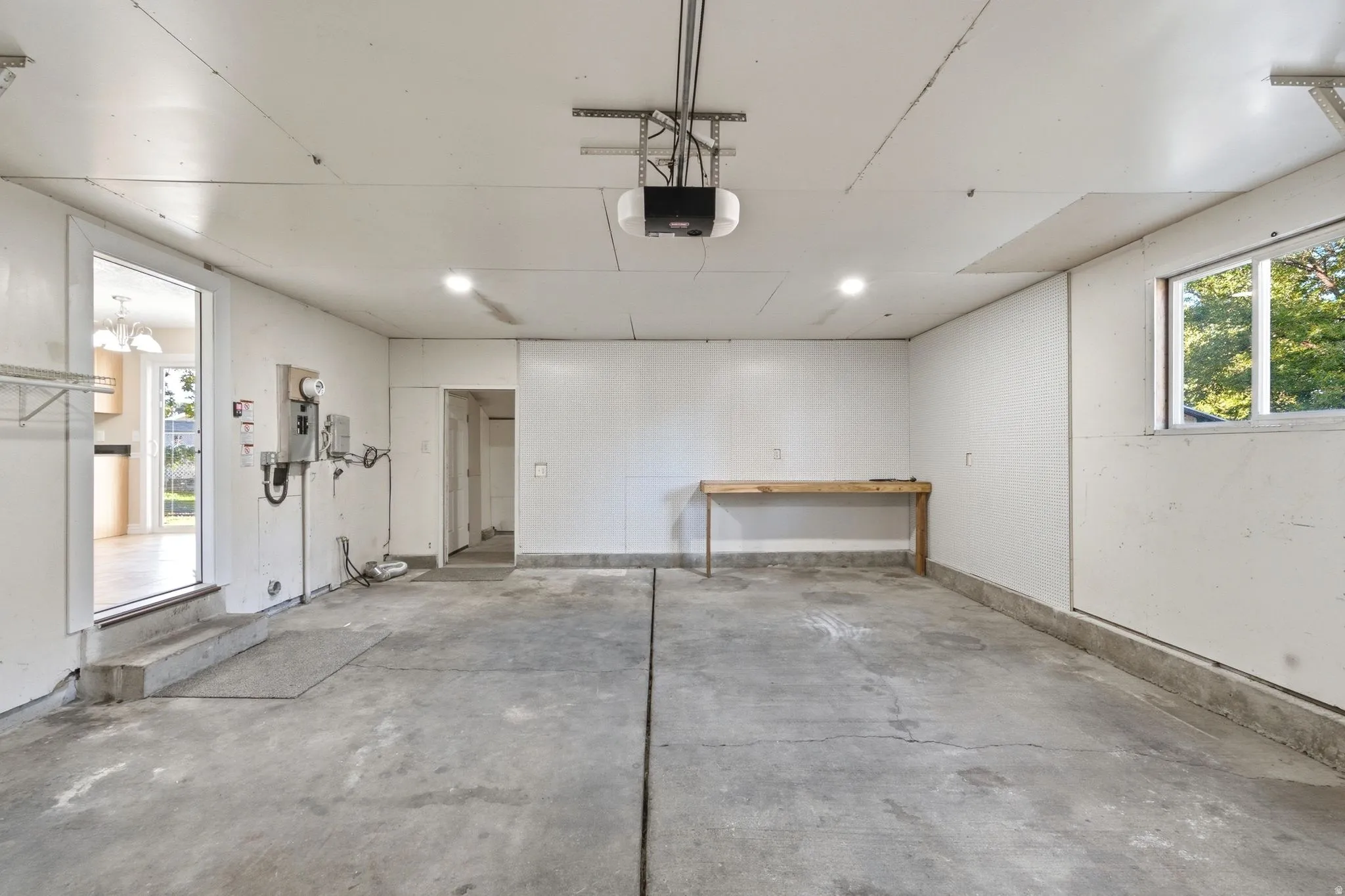 Spacious garage with concrete flooring, recessed lighting, and a built-in workbench