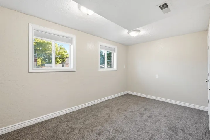 Neutral-toned walls complement the gray carpeting