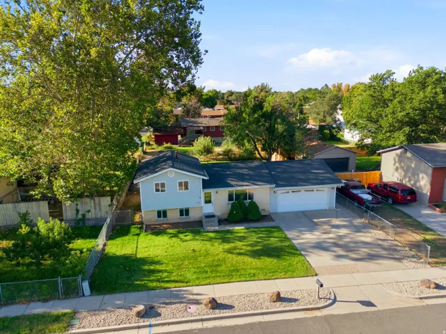 Property featuring a two-car garage, mature landscaping, and a manicured front lawn