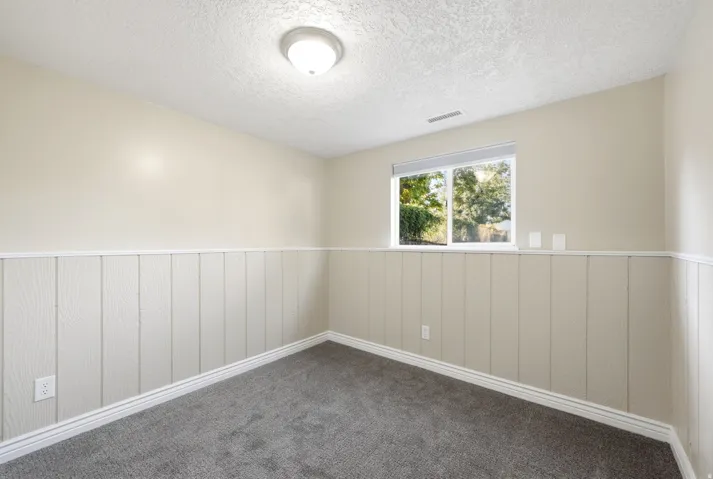 Recessed window with white trim, wood-look wainscoting, and a flush mount ceiling light