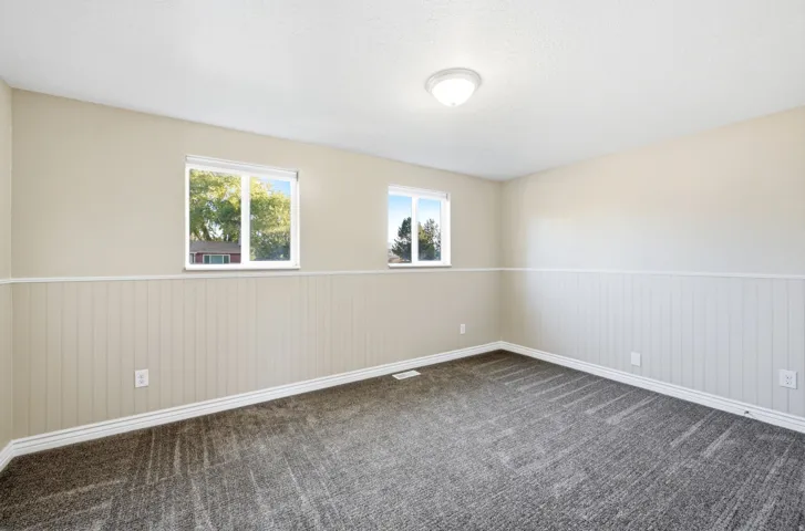 Neutral wall paint with wainscoting detail and two windows
