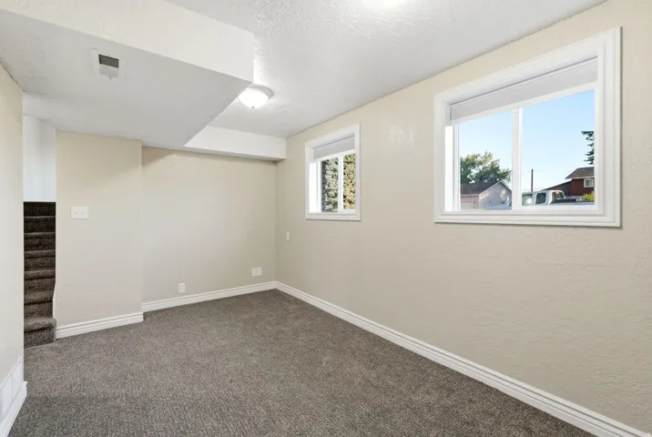 Recessed windows with natural light, neutral wall colors, textured carpeting, and white baseboard trim