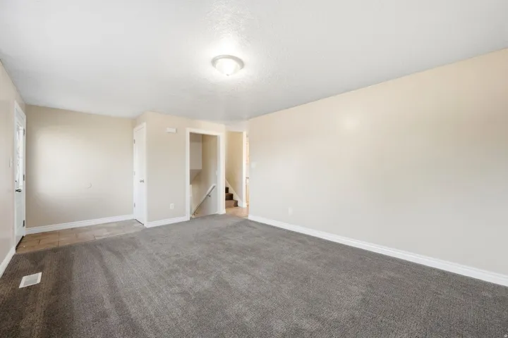 Spacious room with plush gray carpeting and light-toned walls
