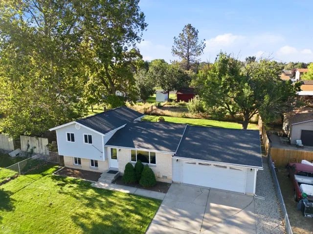 Single-family home featuring a two-car garage, light-toned siding, and a dark shingle roof