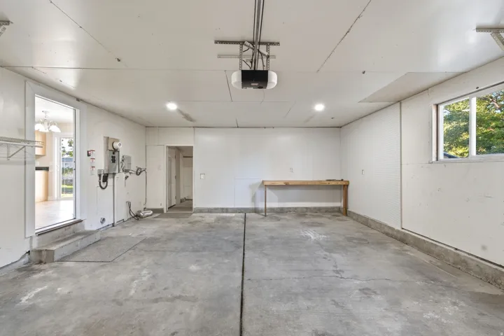 Spacious garage with concrete flooring, recessed lighting, and a built-in workbench