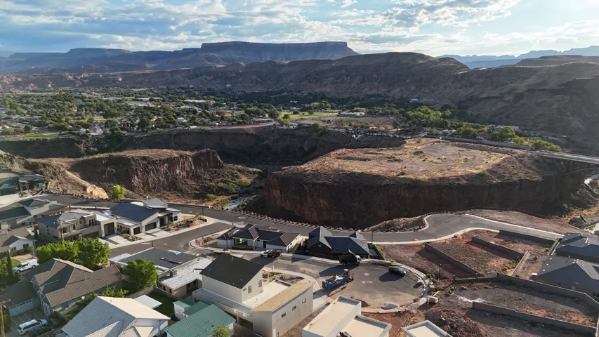 Expansive mountainous terrain, residential properties with varied architectural styles, curved roadways, and established landscaping