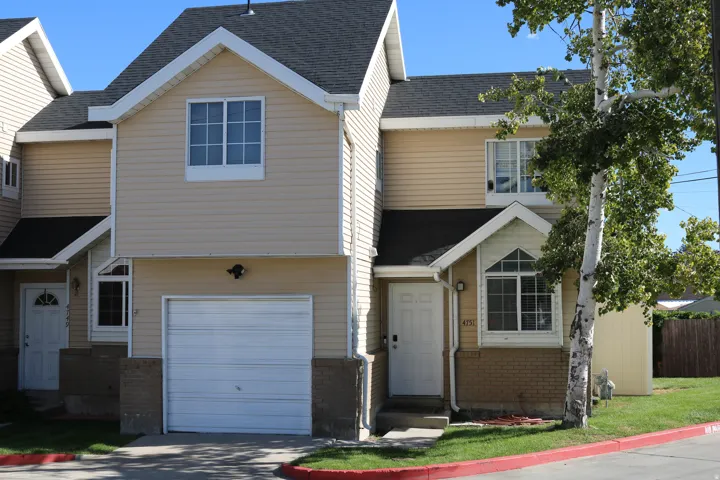 Two-story exterior with siding, attached garage, and pitched roof