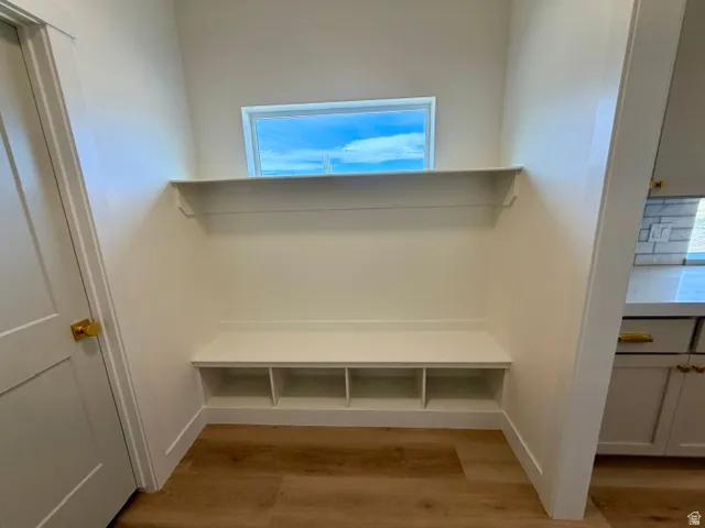 Built-in bench seating with storage cubbies, integrated shelving, and a rectangular transom window