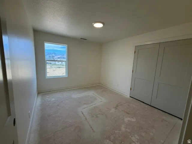 Window with mountain backdrop, recessed ceiling light fixture, white walls, and bi-fold closet doors