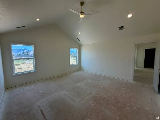 Primary bedroom with vaulted ceiling with recessed lighting and ceiling fan