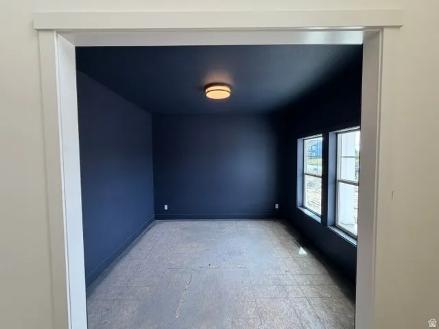 Recessed room entrance with white trim, dark painted walls, flush mount ceiling fixture, and two windows
