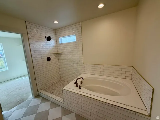 Walk-in shower with subway tile surround, recessed shelf, and bronze fixtures