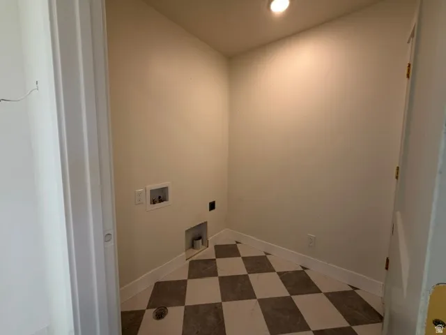 Laundry area featuring checkerboard flooring, recessed lighting, and utility hookups