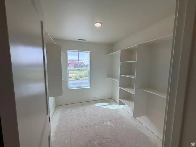 Built-in shelving, recessed lighting, and a single window