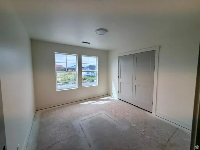 Dual windows, white trim, flush mount ceiling light, and bi-fold closet doors