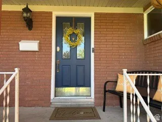 Brick exterior with a dark-paneled door featuring decorative glass inserts and a brass kickplate