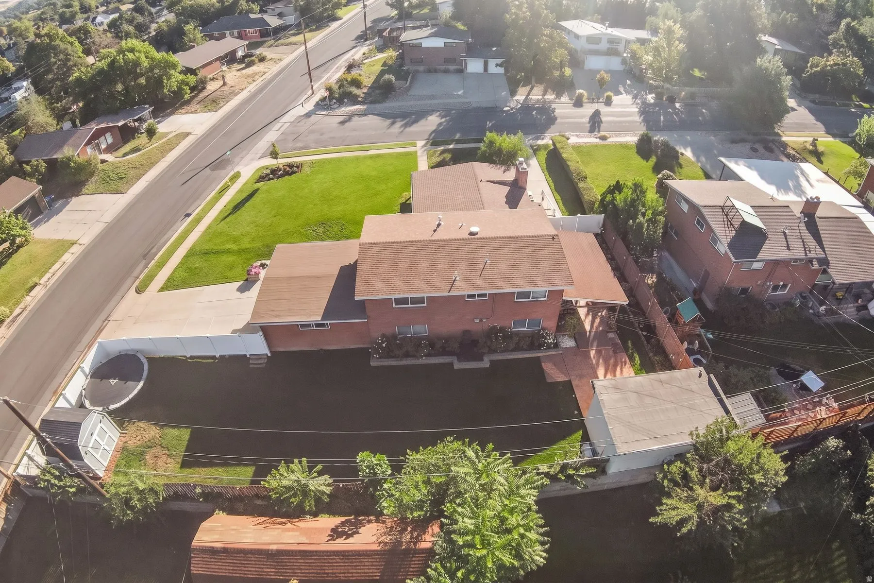Brick exterior, brown shingle roof, expansive front lawn, paved driveway, private fenced backyard