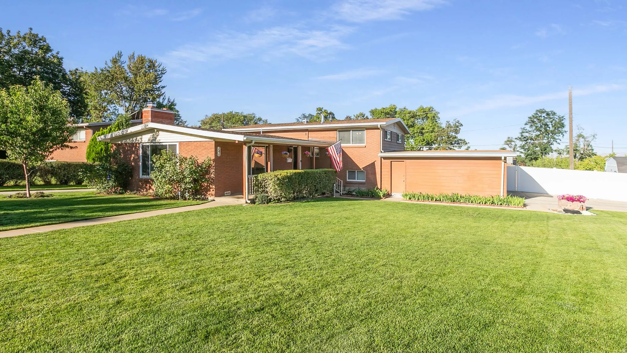 Brick exterior with a prominent chimney and white vinyl fencing