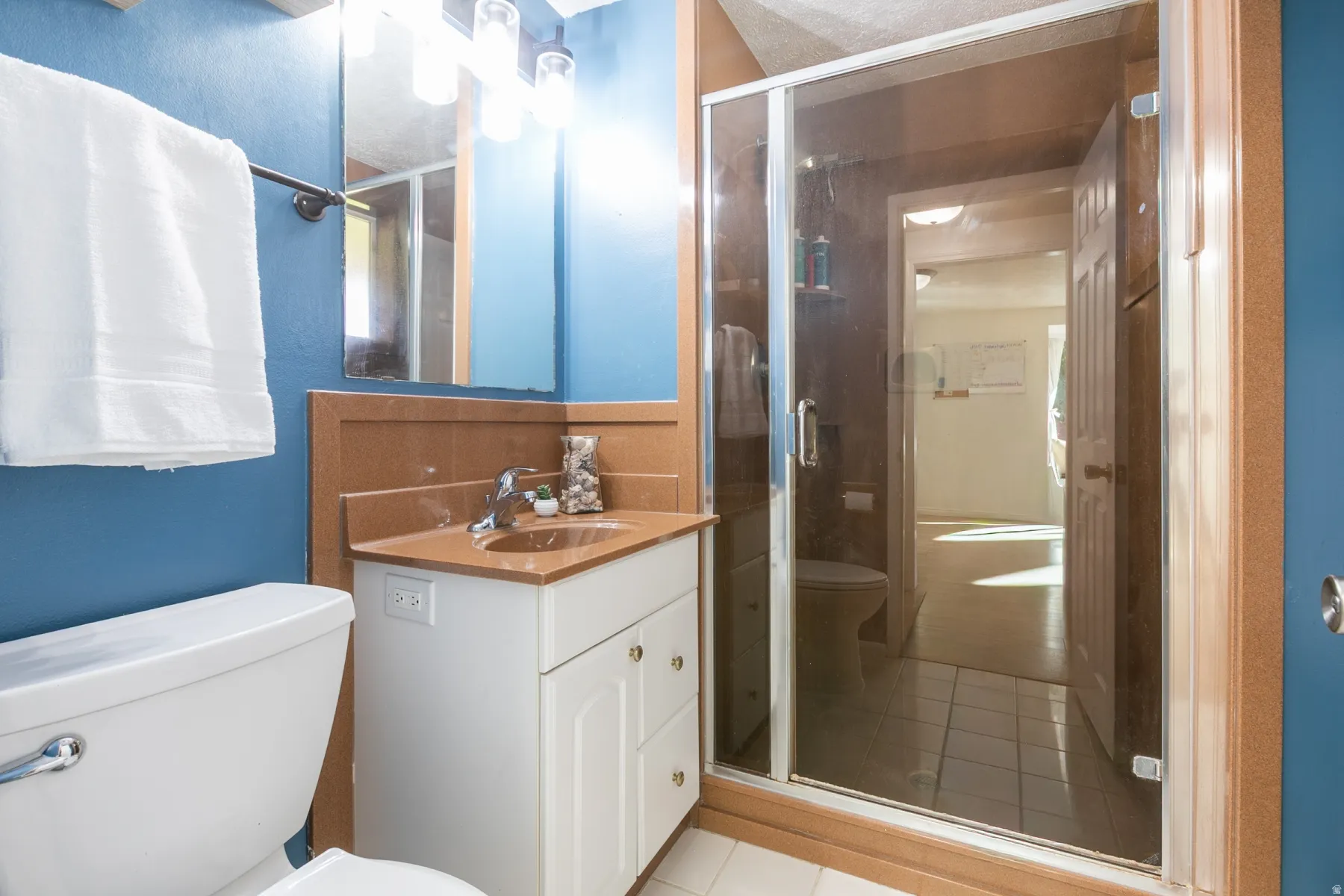 Vanity with an integrated sink, polished chrome fixtures, and a framed mirror