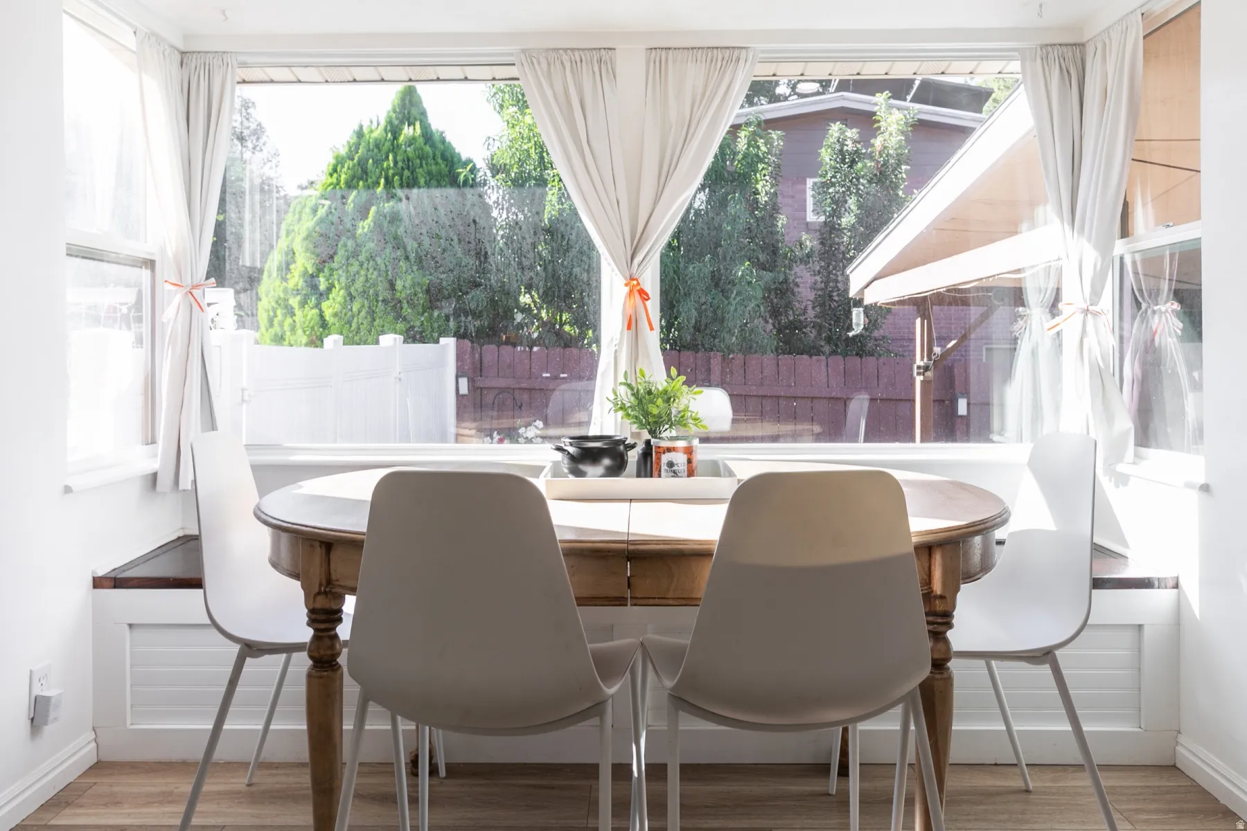 Expansive window with bright natural light, built-in window seating, and wood-finish flooring