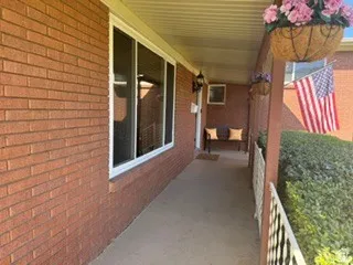 Brick exterior with white window frames and covered porch