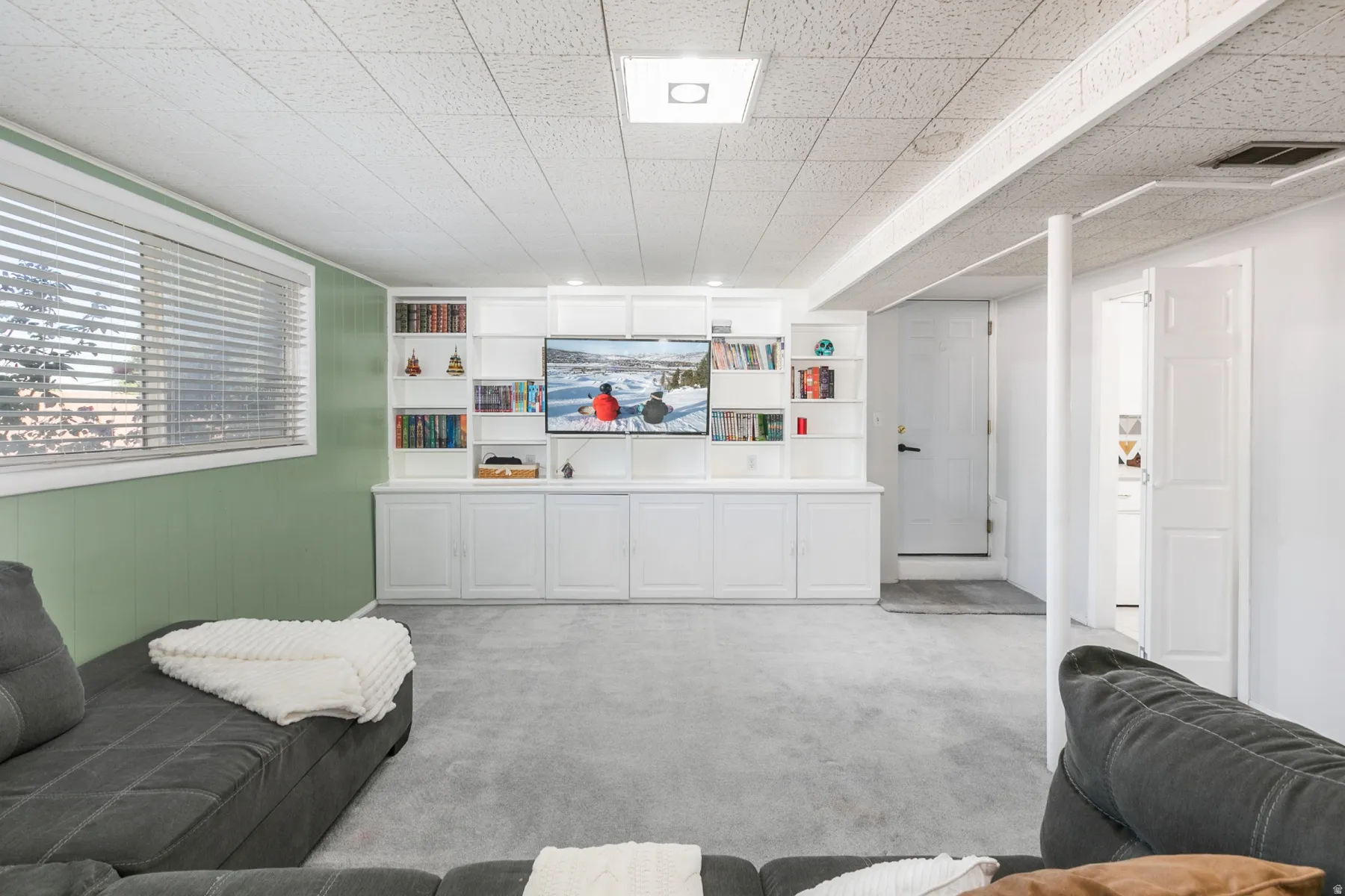 Built-in entertainment center with integrated shelving and closed cabinetry. Door entrance into the garage.
