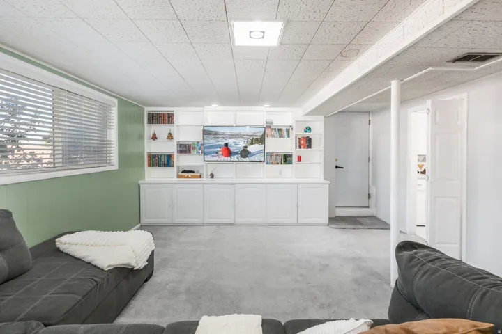 Built-in entertainment center with integrated shelving and closed cabinetry. Door entrance into the garage.