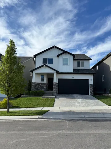 Two-story residence featuring a white exterior with black trim, a gabled roof, and a two-car garage