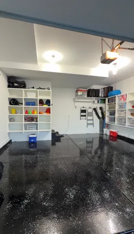 Resin-coated flooring with white flake accents, built-in shelving, and recessed lighting