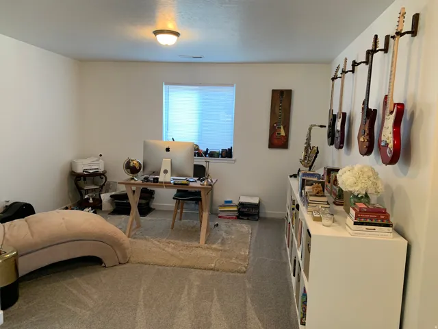 Recessed window with blinds, wall-mounted light fixture, and carpeted flooring