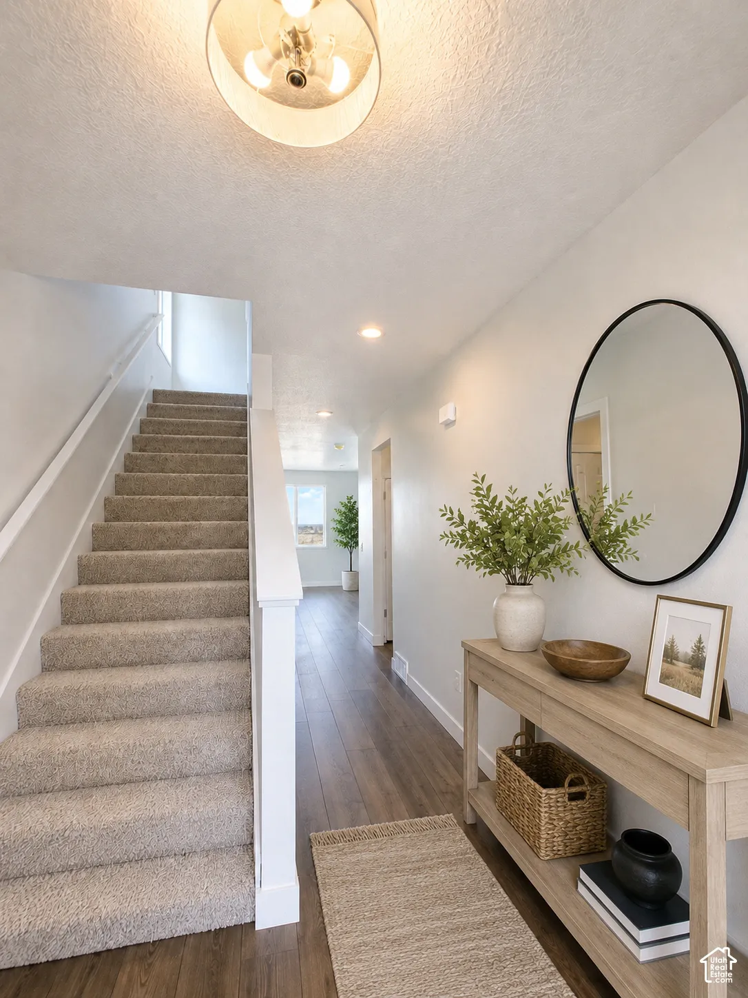 Carpeted staircase with white handrail, wood-finish flooring, recessed lighting, and a drum-style semi-flush mount ceiling light
