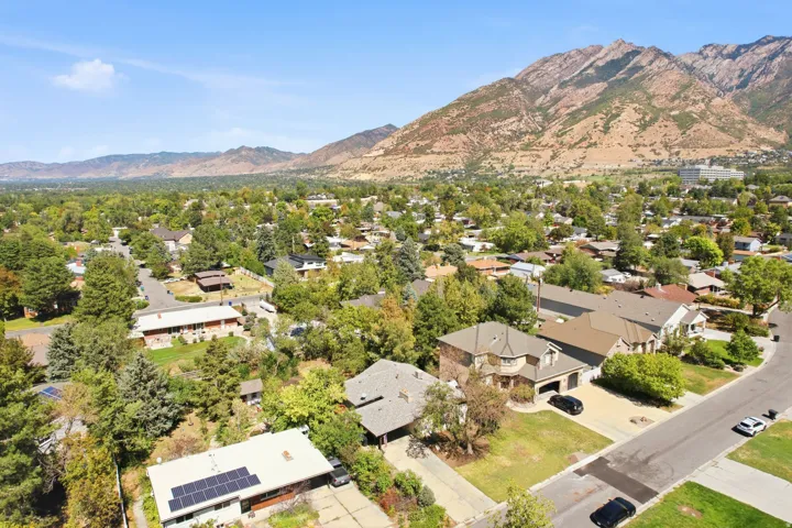 Residential neighborhood with mature trees and mountain scenery