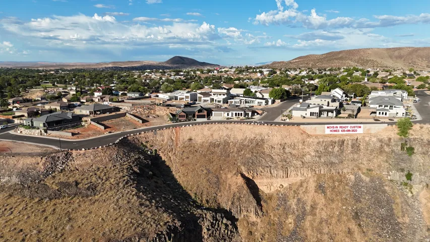 New construction residences located on a graded hillside, featuring paved roads and landscaped common areas