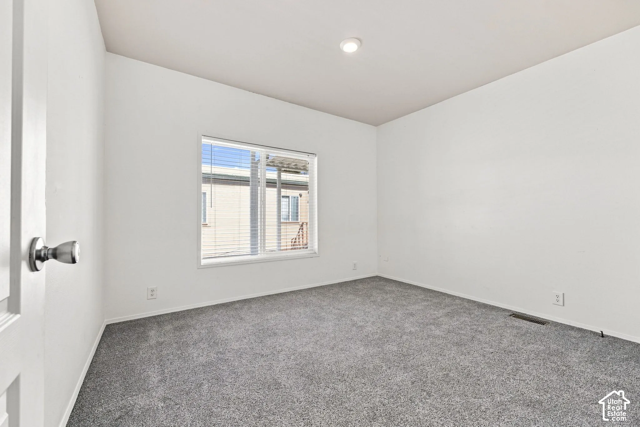 Recessed lighting, neutral wall finishes, gray carpeting, and window blinds