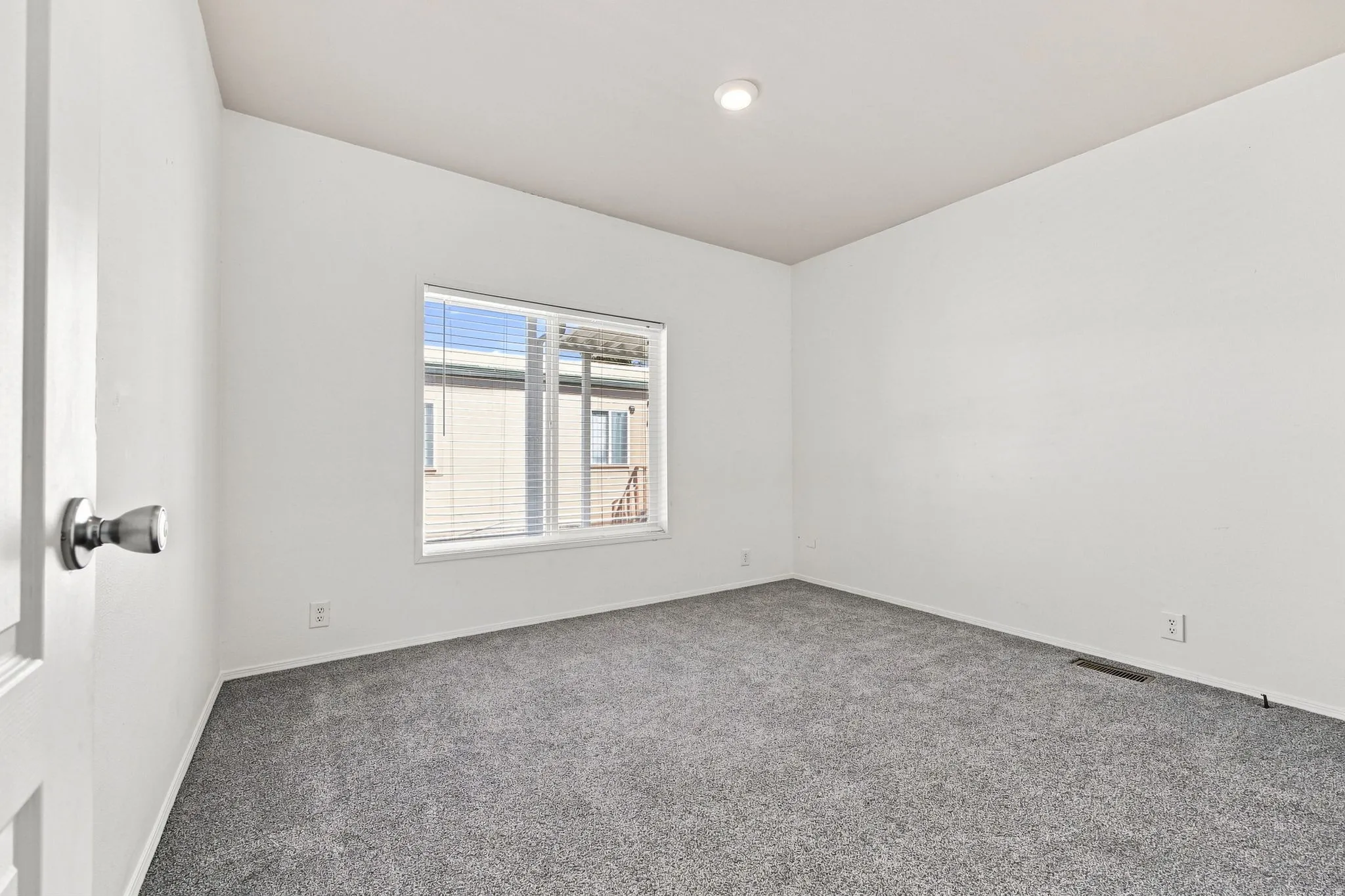 Recessed lighting, neutral wall finishes, gray carpeting, and window blinds