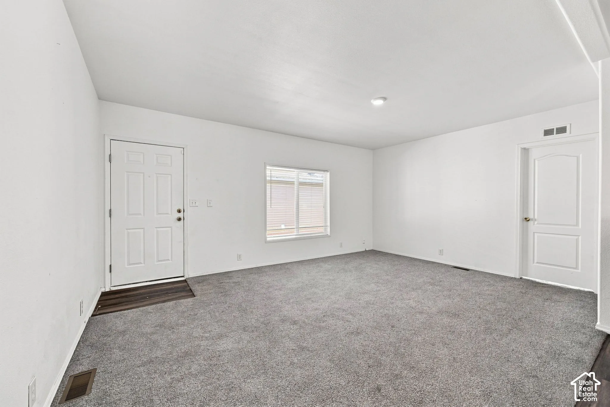Neutral wall finishes, contemporary gray carpeting, recessed ceiling light, paneled interior doors, and a window with blinds