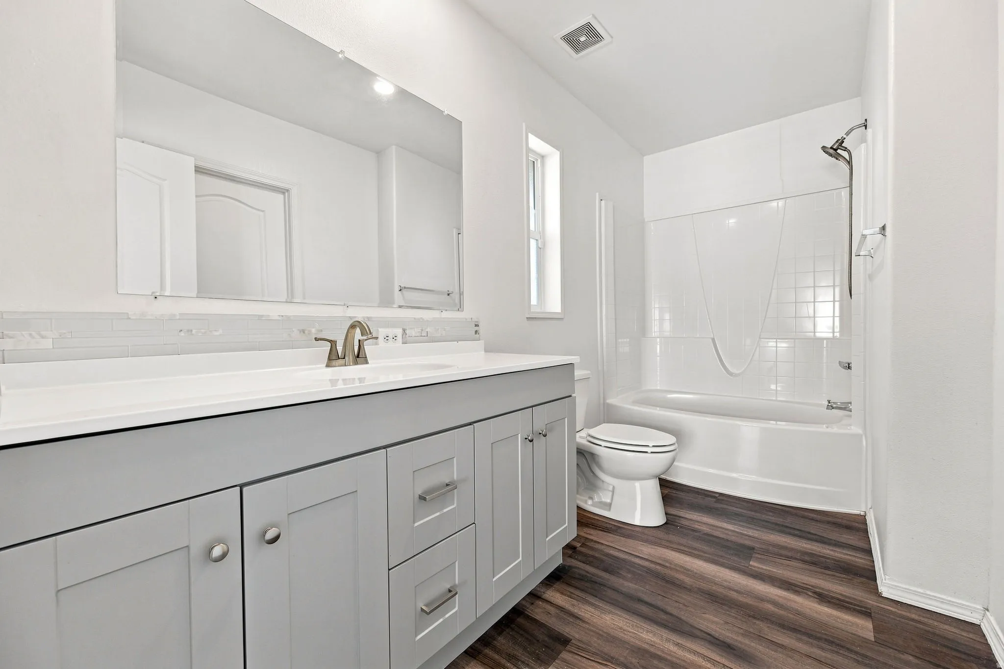 Dual-sink vanity with light gray cabinetry, white countertop, and brushed nickel fixtures