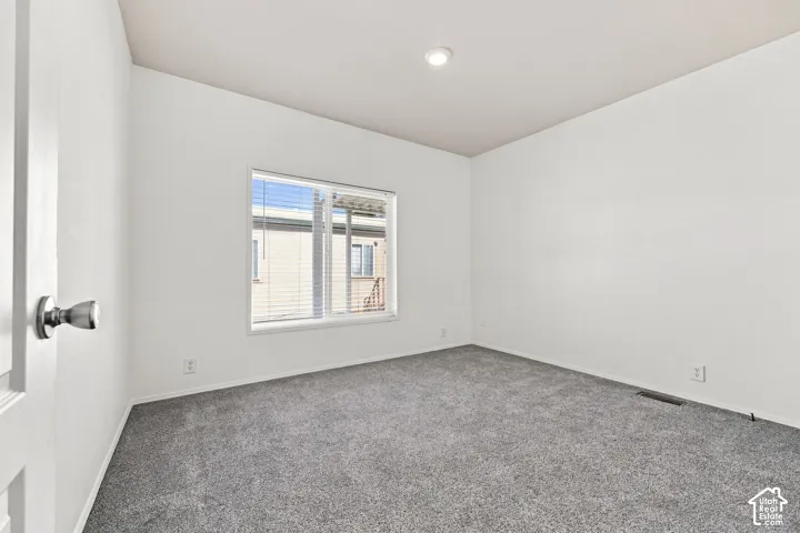 Recessed lighting, neutral wall finishes, gray carpeting, and window blinds