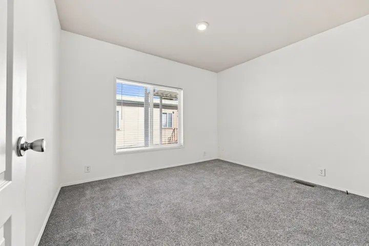 Recessed lighting, neutral wall finishes, gray carpeting, and window blinds